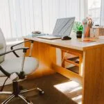 "A clean workspace with a laptop, planner, and a board with inspirational quotes, bright and organized" Keywords: workspace, organized, productive
